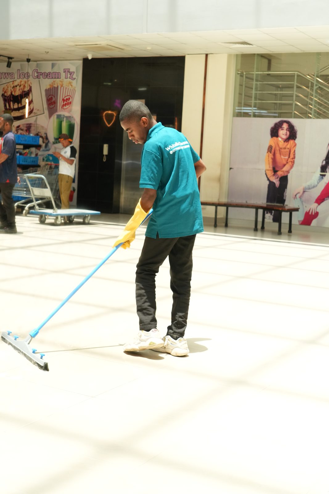 WhiteBird cleaner mopping a large tiled floor in a commercial building